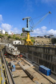 France, Finistère (29), Brest, l'arsenal, le port militaire est une base navale de la Marine nationale, navire de guerre en chantier dans un des deux bassins de radoub de Pontaniou situés dans l’anse de Pontaniou, le batiment aux Lions en arrière plan à droite