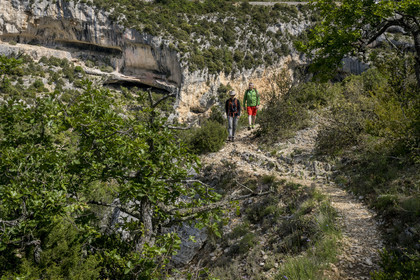 France, Vaucluse, Mont Ventoux Regional Natural Park, Monieux, Gorges de La Nesque, hikers progressing on a path on the heights facing the rocky bars