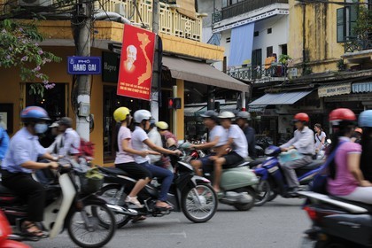 Vietnam, Hanoi, motorcycle traffic in the old city and Ho Chi Minh poster