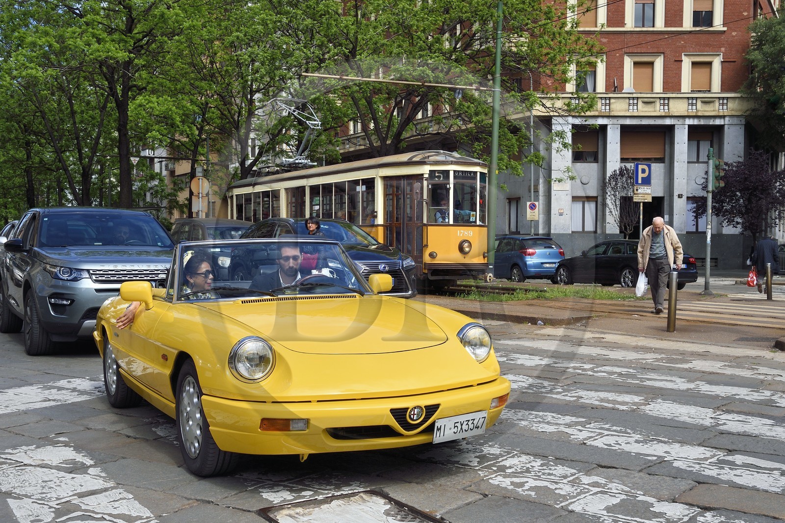 Italy, Lombardy, Milan, Alfa Romeo Duetto Spider yellow cabriolet in the streets of the city