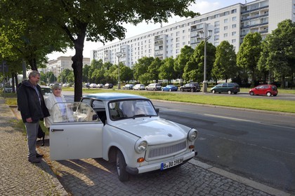 Allemagne, Berlin, la Karl-Marx Allee est la plus grande artère du pays menant d'Alexanderplatz à Frankfurter Tor et le régime communiste y faisait défiler son armée chaque année, famille montant dans leur voiture Trabant