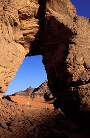 Libye, région du désert, Le Fezzan (Sahara), Touareg sous l'arche (en grès) de Afazedjar dans la Tadrart-Akakus