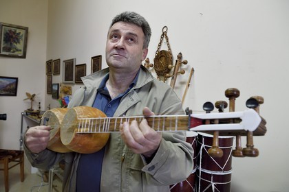 Azerbaïdjan, Sheki (Shaki), fabricant d'instrument à cordes traditionnelles, le luthier Mahir Valadov répare un tar (luth)
