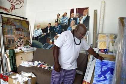 France, Paris (75), Barthelemy Toguo, l'artiste fondateur de Bandjoun Station au Cameroun (représenté dans la peinture en arrière plan), dans son atelier parisien