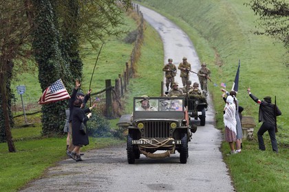 France, Eure (27), Sainte-Colombe-prés-Vernon, Allied Reconstitution Group (association de reconstitution historique de la 2éme Guerre Mondiale américain et Maquis), reconstitueurs en uniforme de la 101e division aéroportée US progressant en jeep Willys accueillis en libérateurs par des villageois et FFI