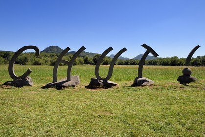 France, Puy de Dome, Saint-Ours-les-Roches, hamlet of Beauregard, Parc Naturel Régional des Volcans d'Auvergne (regional nature park of Auvergne volcanoes), Chut !, sculpture by artist Thierry Courtadon, in the background the volcano Le Puy Chopine on the left and the Puy de Dome on the right