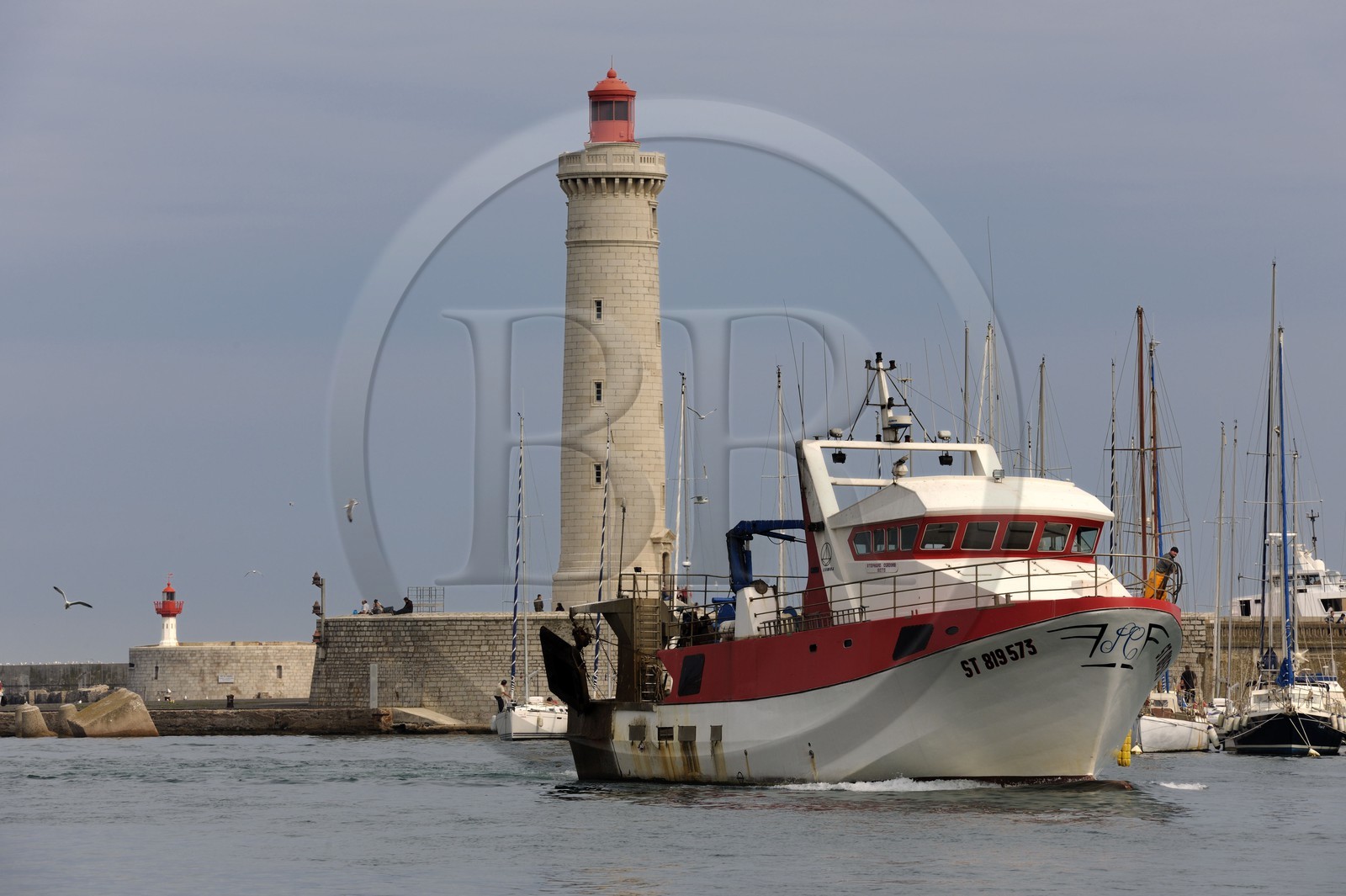France, Hérault (34), Sète, Vieux Port, retour de pêche d'un chalutier et le phare du Môle Saint-Louis