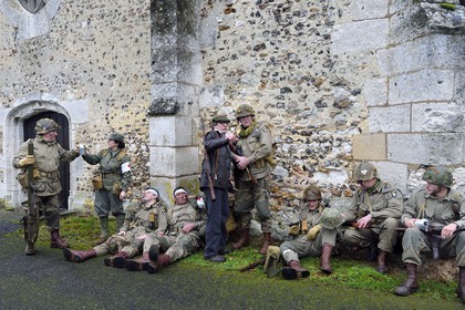 France, Eure (27), Chambray, Allied Reconstitution Group (association de reconstitution historique de la 2éme Guerre Mondiale US et Maquis), reconstitueurs en uniforme de la 101e division aéroportée US et de maquisards des Forces françaises de l'intérieur (FFI) au repos devant l'église