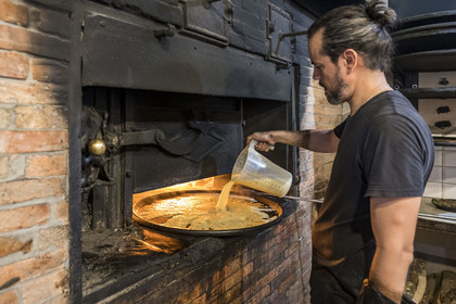 France, Alpes-Maritimes (06), Nice classée Patrimoine Mondial de l'UNESCO, le Vieux Nice, Antoine à la fabrication de la socca de Chez Theresa dans la rue Droite, galette à base de farine de pois chiche et spécialité de Nice