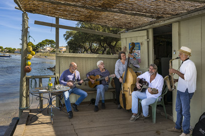 France, Hérault (34), Sète,  Pointe du Barrou sur les rives de l'étang de Thau, le groupe de musique Au Bois de mon cœur qui réinterprète les chansons de Georges Brassens, il est mené par le pêcheur sétois Jean-Louis Lambert au chant et à la guitare, Georges Cabaret à la guitare solo, Guy Blanc dit Guet au saxo alto, Denis Benito à la mandoline bluegrass et Tatiana à la contrebasse