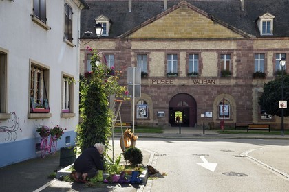 France, Haut-Rhin (68), Neuf-Brisach, ville fortifiée par Vauban, classée Patrimoine Mondial de l'UNESCO, la Porte de Belfort et le musée Vauban au sud-ouest et végétalisation de la rue par une voisine