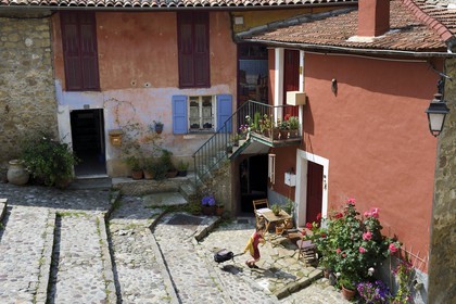 France, Alpes-Maritimes, Coaraze, labelled Les Plus Beaux Villages de France (The Most Beautiful Villages of France), child going to school in the stepped streets