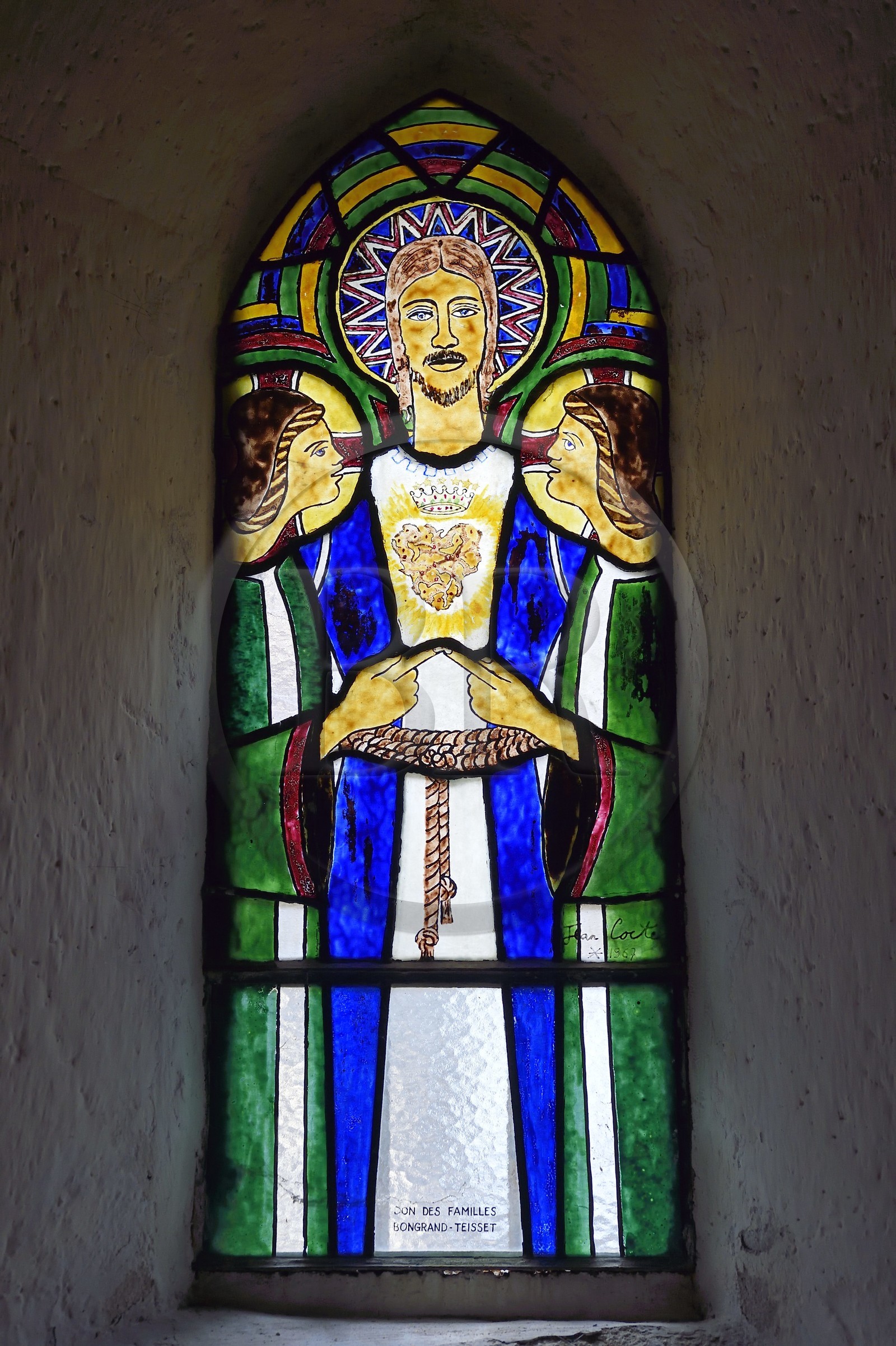 France, Cantal, Sainte-Marie, Sainte-Agathe church, stained glass window designed by Jean Cocteau and made in Saint Jean Cap Ferrat in the Pelissier workshops, Christ surrounded by two angels whose indexes meet represents a Sacred Heart
