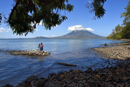Nicaragua, Ile d'Ometepe sur le lac Nicaragua, village de Merida, femme faisant sa lessive dans le lac et le volcan Conception (1610 m) en arrière plan