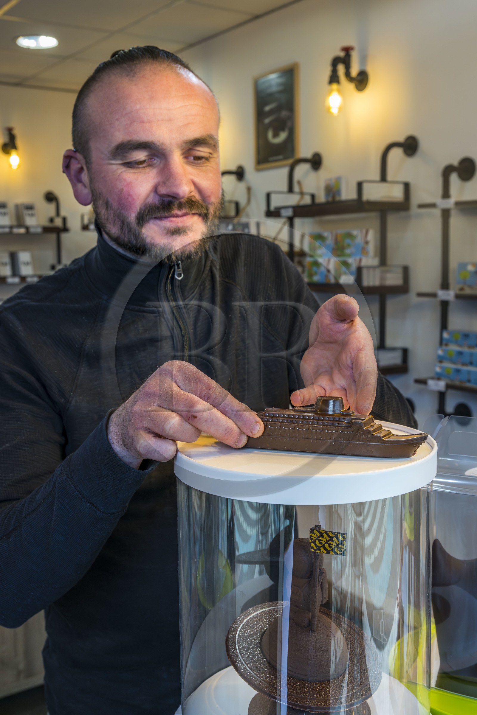 France, Loire-Atlantique, Saint-Nazaire, Master chocolatier Guillaume Menand in his shop with one of his creations, the ocean liner