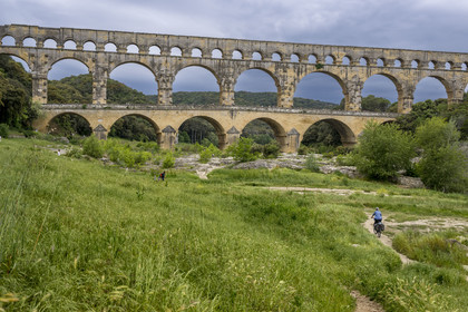 France, Gard (30), le Pont du Gard classé Patrimoine Mondial de l'UNESCO, Grand Site de France, cycliste arrivant au pont aqueduc romain qui enjambe le Gardon