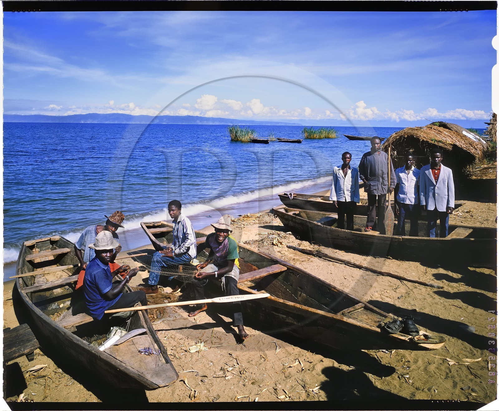 Burundi, province de Rumonge, groupe de pêcheurs au bord du lac Tanganyika, les pêcheurs sont exclusivement Hutu et descendent des collines pour s'installer dans des huttes provisoires pour au moins 6 mois, la pêche se pratique généralement la nuit au lamparo et c'est principalement des ndagalas (poisson à friture) des mukekes et des capitaines, en arrière plan on apercoit la pointe de Burton et Speke située au Congo (reproduction plan-film inversible 4x5)