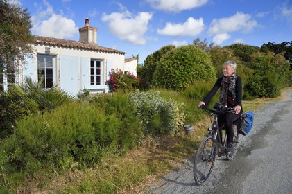 France, Charente-Maritime (17), Ile d'Aix, cycliste faisant la véloroute La Flow Vélo passant devant une petite maison de pêcheur typique