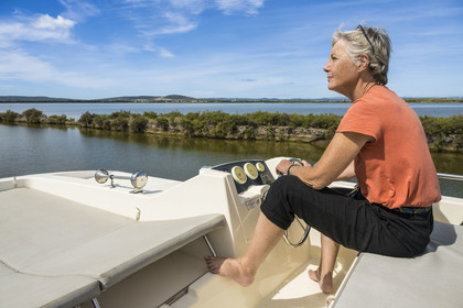 France, Hérault (34), Villeneuve-lès-Maguelone, navigation d'un bateau de plaisance Le Boat sur le canal du Rhône à Sète en bordure de l'étang l'Arnel en arrière plan
