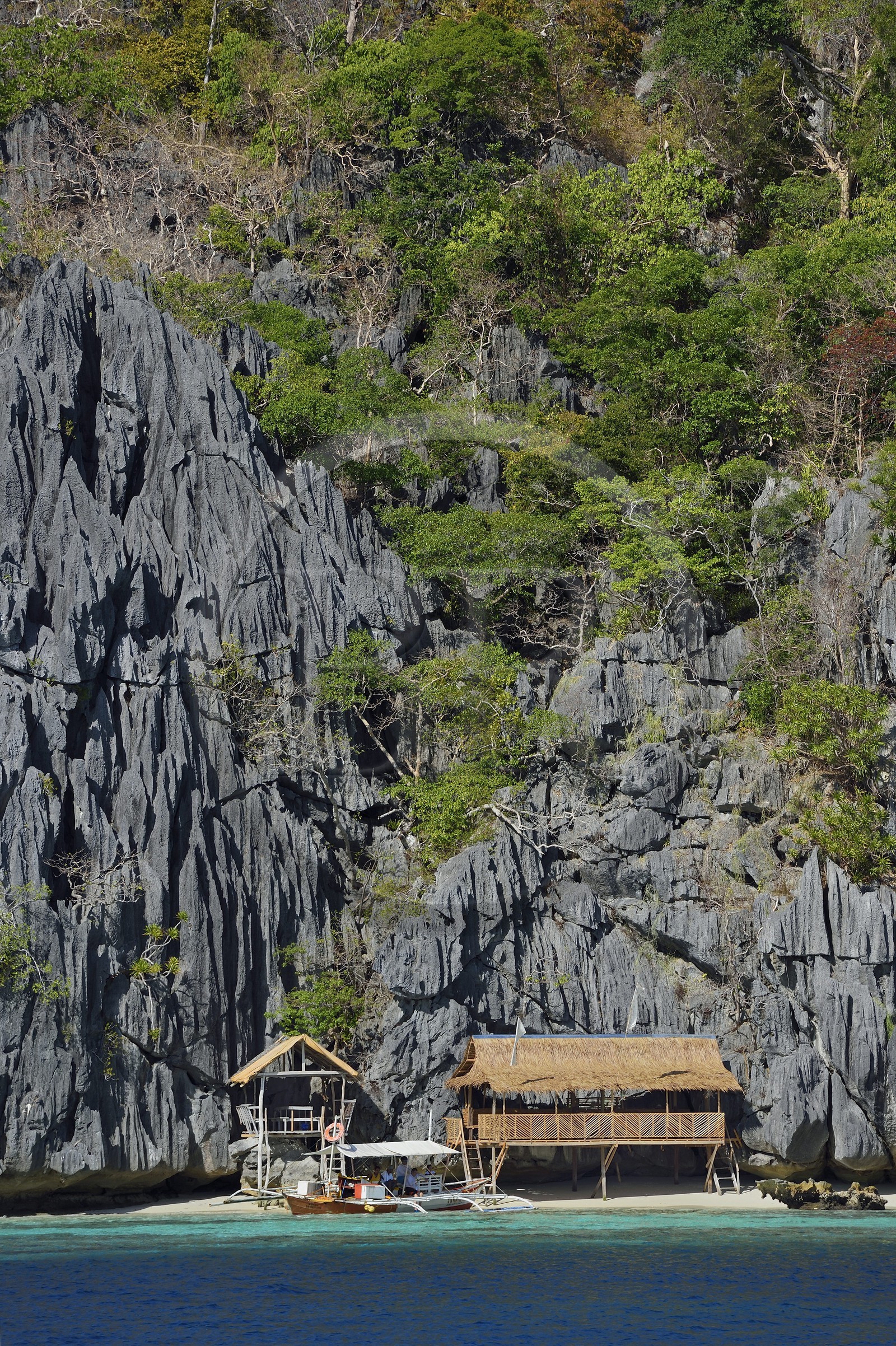 Philippines, Calamian Islands in northern Palawan, Coron Island Natural Biotic Area, beach under giant walls of limestone cliffs