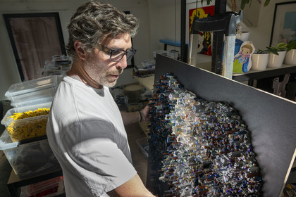 France, Côte-d'Or (21), Dijon, l'artiste Aymeric Gillet alias M'Brick dans son atelier rempli de caisses de Légo multicolores utilisés pour créer des tableaux géants pixellisés inspirés par la pop culture