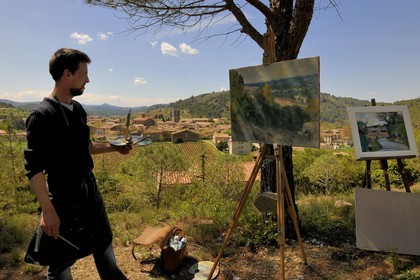 France, Aude (11), village de Lagrasse, labellisé Les Plus Beaux Villages de France, artiste peintre devant le village