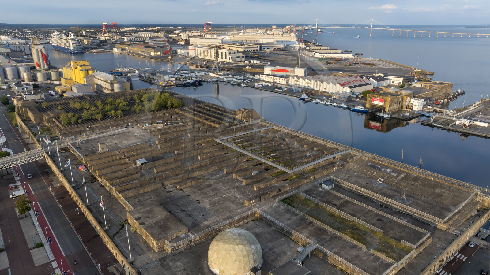 France, Loire Atlantique, Saint Nazaire, the former German submarine bases built during the last world war border the water basin of the port of Saint-Nazaire, in the background on the left the Penhoët basin and on the right the Saint-Nazaire bridge (aerial view)