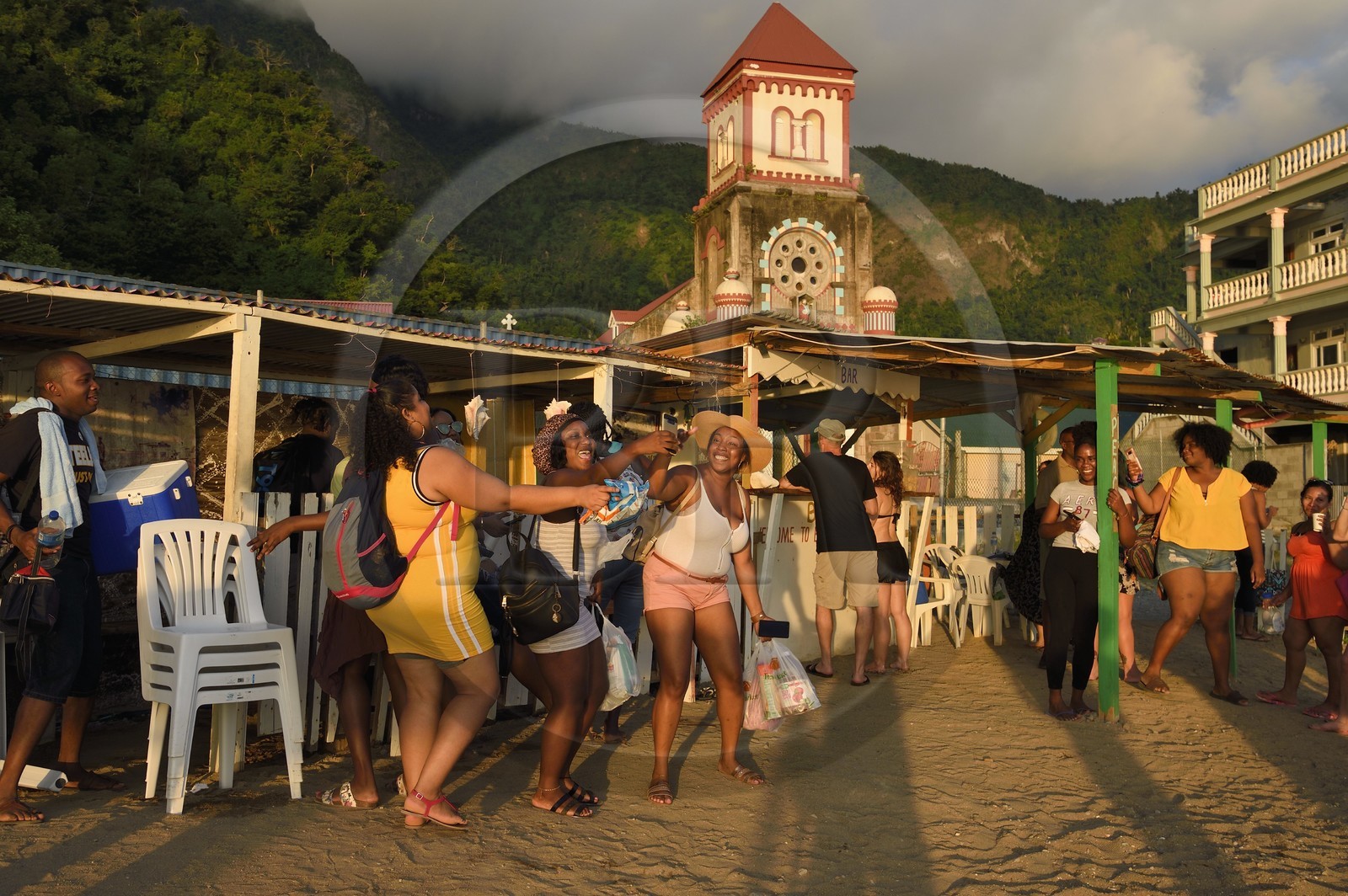 Caraïbes, Ile de la Dominique, baie de Soufrière, le village de Soufrière, bar à rhum sur la plage et l'église catholique de Saint-Marc en arrière plan