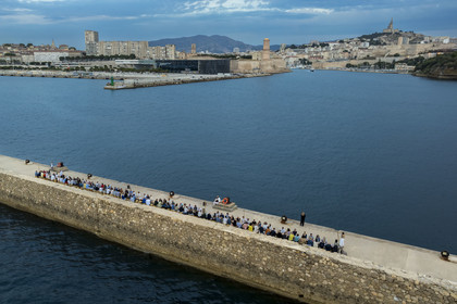 France, Bouches-du-Rhône (13), Marseille, Zone Euroméditerranée, grand port maritime de Marseille (GPMM), la digue du large, convives attablés à une grand table de banquet dressée par le chef Emmanuel Perrodin dans le cadre des Diners Insolites, le Mucem, le Fort Saint-Jean et la basilique Notre Dame de la Garde en arrière plan (vue aérienne)