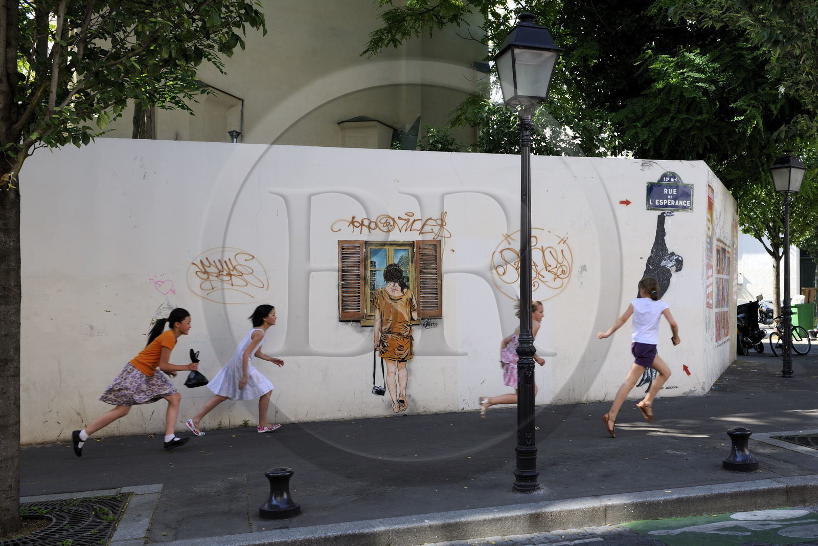 France, Paris (75), quartier de la Butte-aux-Cailles, enfants courant rue de l'Espérance sous un graffity de Lézards