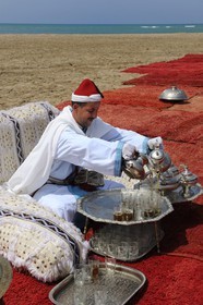 Maroc, région de l'Oriental, service du thé à la menthe en costume d'apparat sur une plage