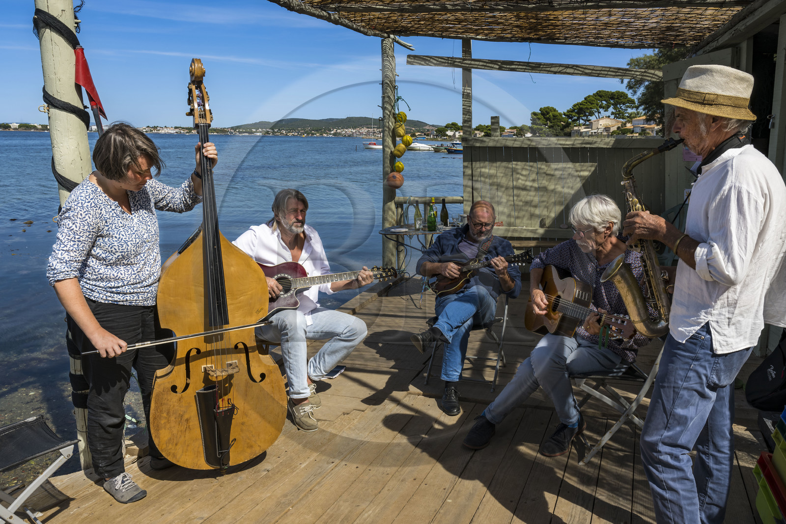 France, Hérault (34), Sète,  Pointe du Barrou sur les rives de l'étang de Thau, le groupe de musique Au Bois de mon cœur qui réinterprète les chansons de Georges Brassens, il est mené par le pêcheur sétois Jean-Louis Lambert au chant et à la guitare, Georges Cabaret à la guitare solo, Guy Blanc dit Guet au saxo alto, Denis Benito à la mandoline bluegrass et Tatiana à la contrebasse