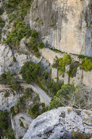 France, Hérault (34), Causses et les Cévennes, paysage culturel de l'agro-pastoralisme méditerranéen, classés Patrimoine Mondial de l'UNESCO, Saint-Guilhem-le-Désert, labellisé Les Plus Beaux Villages de France, randonneurs sur la Via Tolosana sur le Chemin de Saint-Jacques-de-Compostelle, le passage des Fenestrelles aménagé au Moyen-age par les moines de l'abbaye afin de franchir ce verrou rocheux dans le cirque de l'Infernet