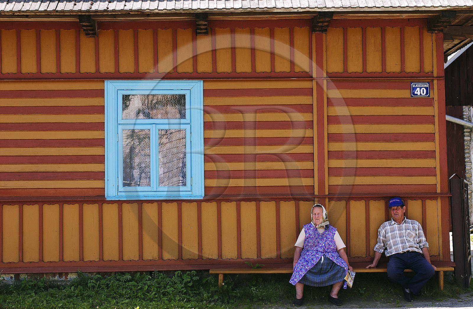 Pologne, Petite Pologne, Carpates, paysanne assis devant sa maison en bois peint dans le village de Debno