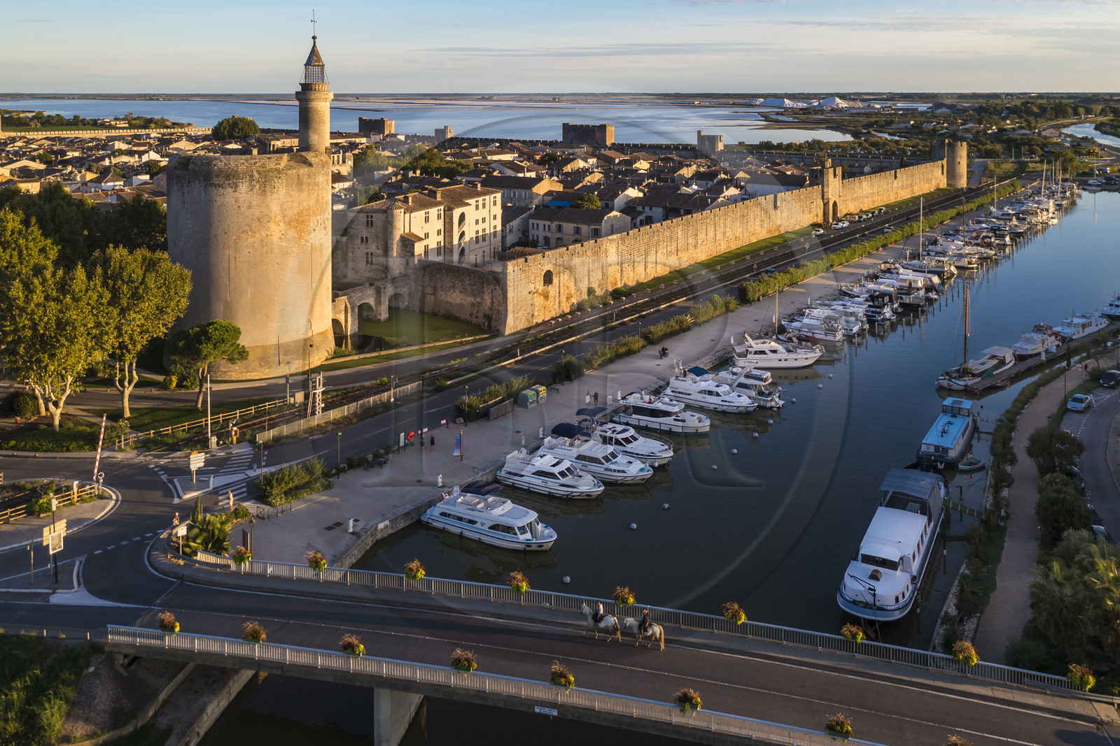 France, Gard (30), Aigues-Mortes, la ville médiévale entourée par ses remparts, la Tour de Constance et le port du canal du Rhône à Sète au premier plan, les marais salants (Salins du Midi) en arrière plan (vue aérienne)