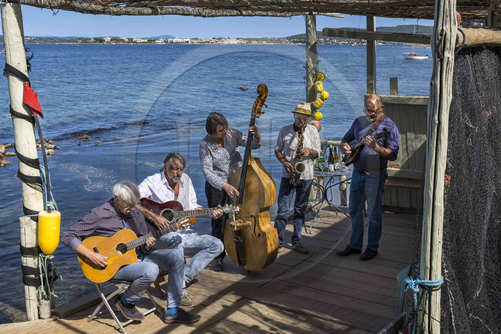 France, Hérault (34), Sète,  Pointe du Barrou sur les rives de l'étang de Thau, le groupe de musique Au Bois de mon cœur qui réinterprète les chansons de Georges Brassens, il est mené par le pêcheur sétois Jean-Louis Lambert au chant et à la guitare, Georges Cabaret à la guitare solo, Guy Blanc dit Guet au saxo alto, Denis Benito à la mandoline bluegrass et Tatiana à la contrebasse