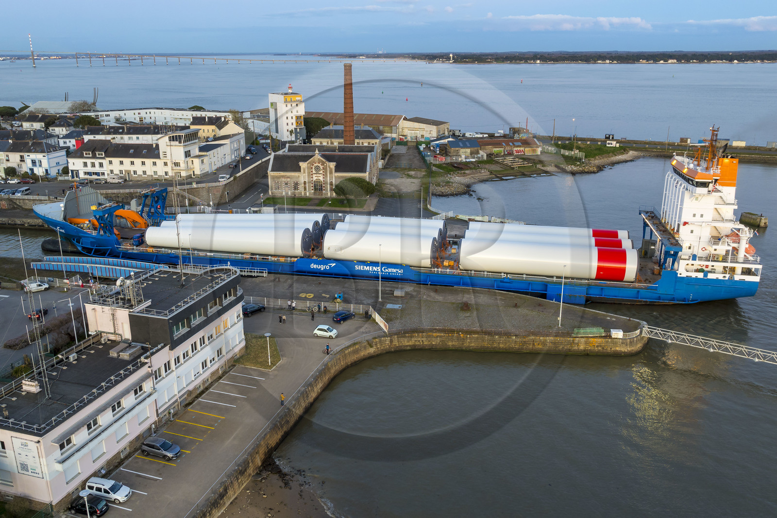 France, Loire-Atlantique (44), Saint-Nazaire, le General Cargo Rotra Mare transporte des sections des mats d'éoliennes et entre dans le bassin à flot du port (en arrière plan) par  l'écluse sud, qui est aussi le lieu de l’Opération Chariot lancée en 1942 par les Britanniques (vue aérienne)