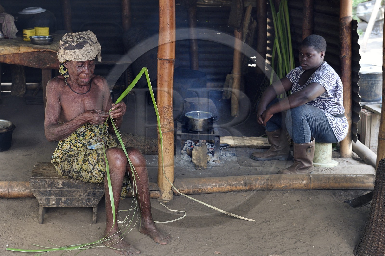 Gabon, province de Ogooué- Maritime, région de Omboué, Nengeue Sika (ile d’argent) dans la lagune Fernan Vaz (Nkomi), vieille femme préparant une tresse dans sa case