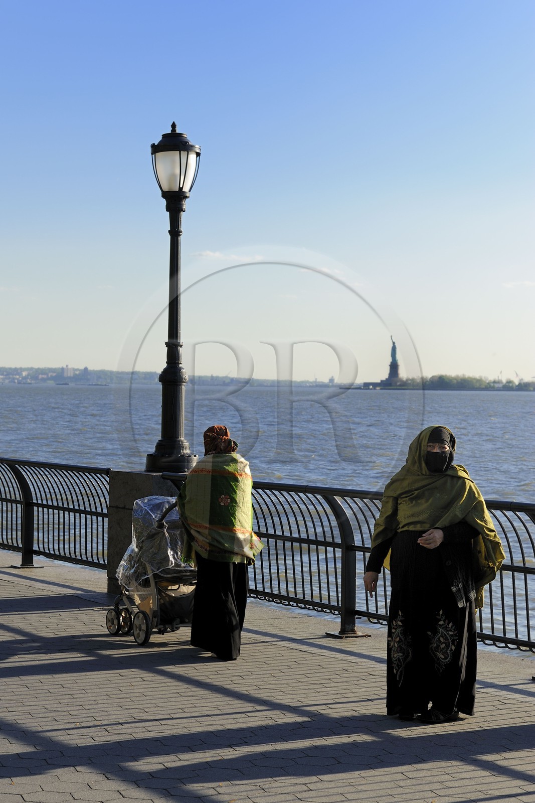 Etats-Unis, New York, Manhattan, pointe Sud, femmes voilée en promenade sur Battery Park et la Statue de la Liberté en arrière plan
