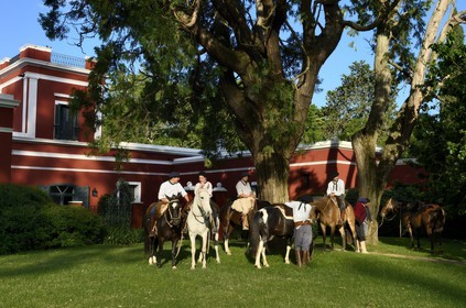 Argentine, province de Buenos Aires, San Antonio de Areco, groupe de gauchos à cheval devant l'estancia La Bamba de Areco