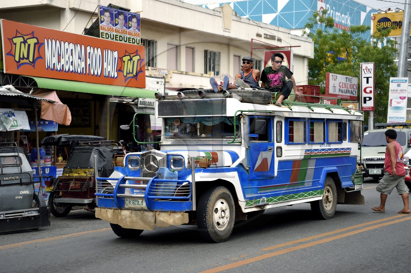 Philippines, province de Nueva Ecija, Bambang, jeepney (jeep allongée pour le transport de passagers) avec passagers sur le toit dans la rue principale