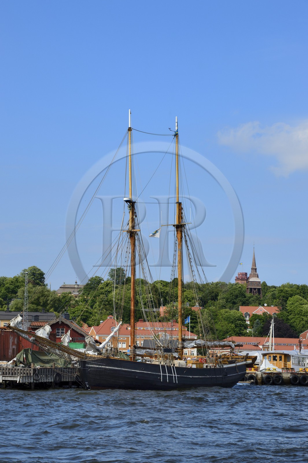 Sweden, Stockholm, old ship in the Beckholmen Island shipyard and the Hallestad belfry in the open air museum Skansen in the background