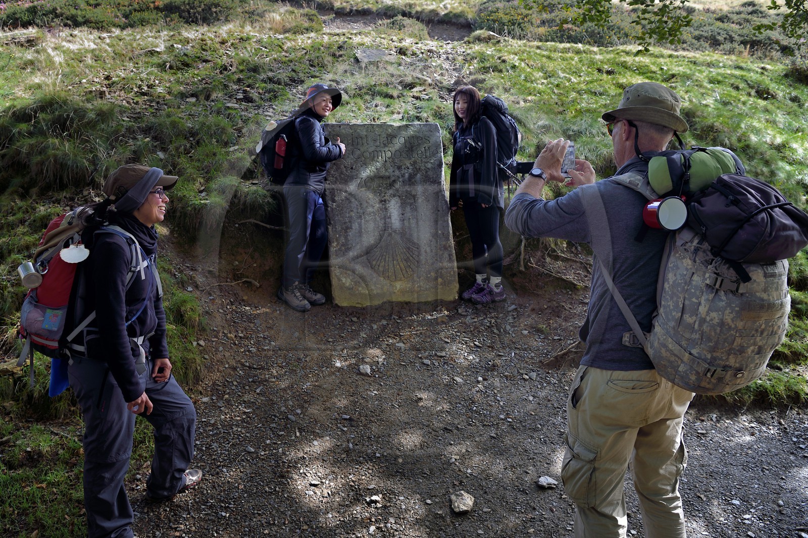 France, Pyrénées-Atlantiques (64), Pays-Basque, chemin de Saint-Jacques de Compostelle sur le GR 65 entre Saint-Jean-Pied-de-Port et Roncevaux vers le col de Bentarte, pèlerins devant la stèle indiquant que Compostelle est encore à 765 km