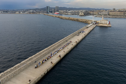 France, Bouches-du-Rhône (13), Marseille, Zone Euroméditerranée, grand port maritime de Marseille (GPMM), la digue du large, convives attablés à une grand table de banquet dressée par le chef Emmanuel Perrodin dans le cadre des Diners Insolites, la tour CMA CGM et tour La Marseillaise en arrière plan (vue aérienne)