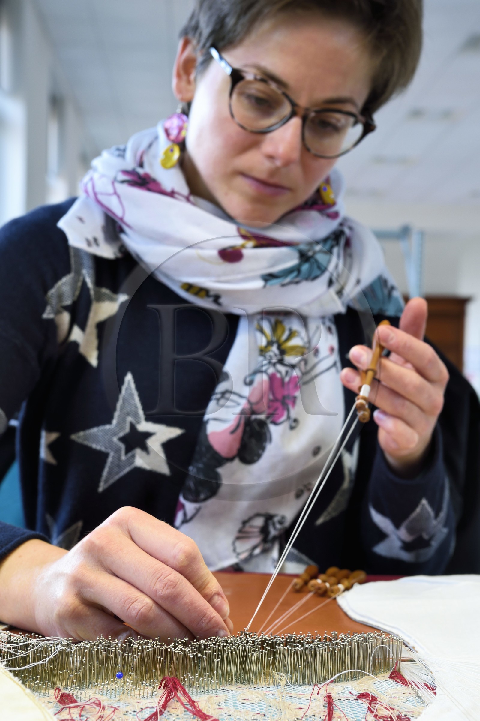 France, Haute-Loire (43), Le Puy-en-Velay, Atelier conservatoire national de la dentelle du Puy, dentelle au fuseau sur des créations d’artistes commandées par le département du mobilier national, la technicienne d'art (dentellière) Carole Cubizolles sur un carreau traditionnel