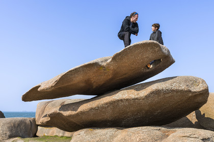 France, Côtes-d'Armor (22), Côte de Granit Rose, Trégastel, Ile Renote, le chaos granitique, Pierre et son fils Alexandre sur le rocher appelé la palette du peintre