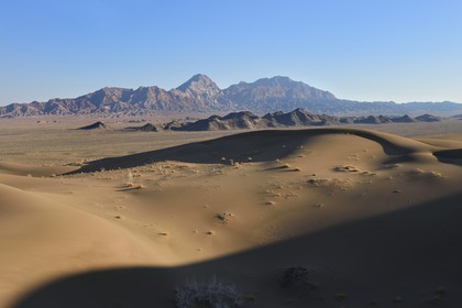 Iran, Province de Yazd, désert du Dasht-e Kavir, Moghestan, le massif montagneux de Moghestan face aux dunes dont la plus haute atteint les 200 mètres