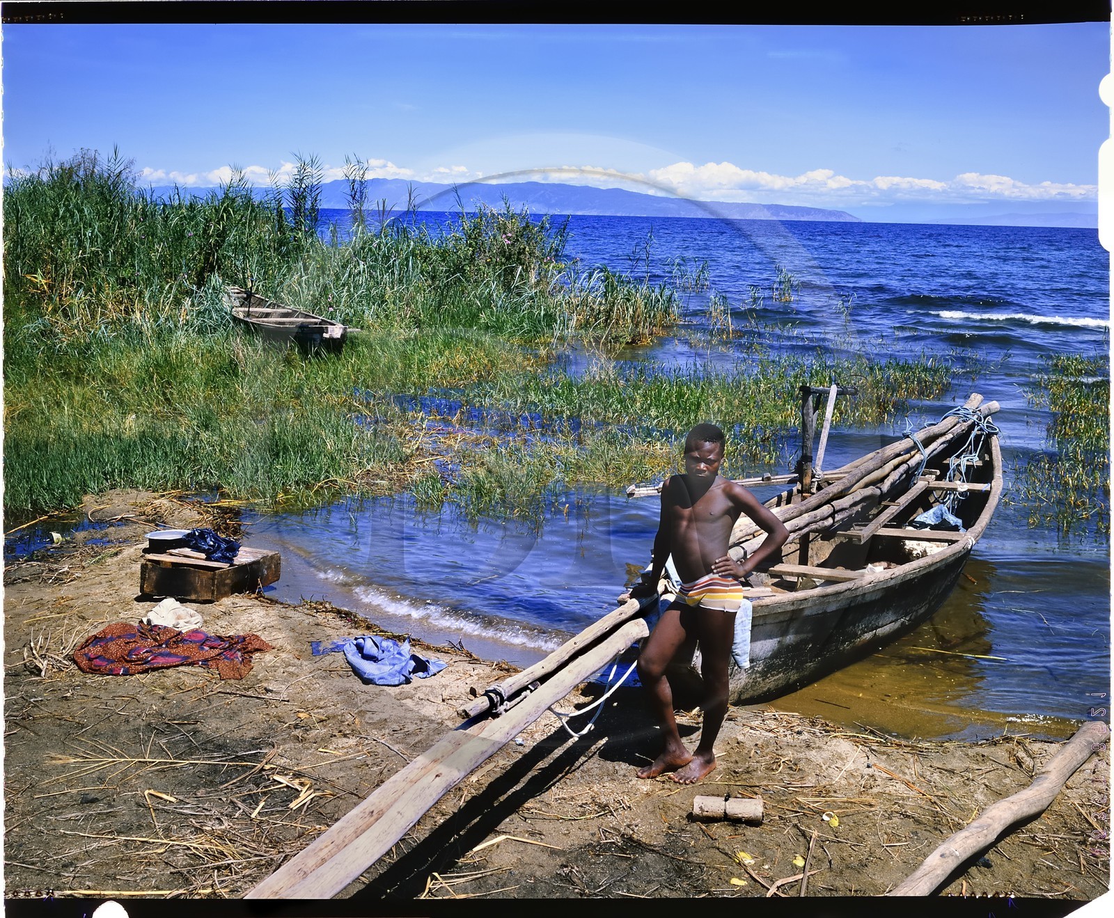 Burundi, Rumonge Province, young Hutu fisherman on Lake Tanganyika, fishermen are exclusively Hutu and come down from the  hills to settle in temporary huts for at least 6 months, fishing is generally done at night with lampara and it's mainly ndagalas (fried fish) mukekes and Lates niloticus, in the background we perceives the tip of Burton and Speke located in the Congo (4x5 reversal film reproduction)