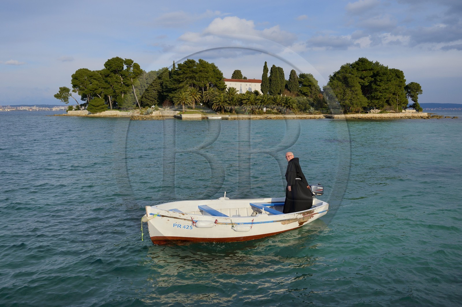 Croatia, Dalmatia, Dalmatian Coast, Ugljan Island, Preko, Franciscan friar Bozo Susic leaving the Franciscan Monastery of the Galovac island on his boat