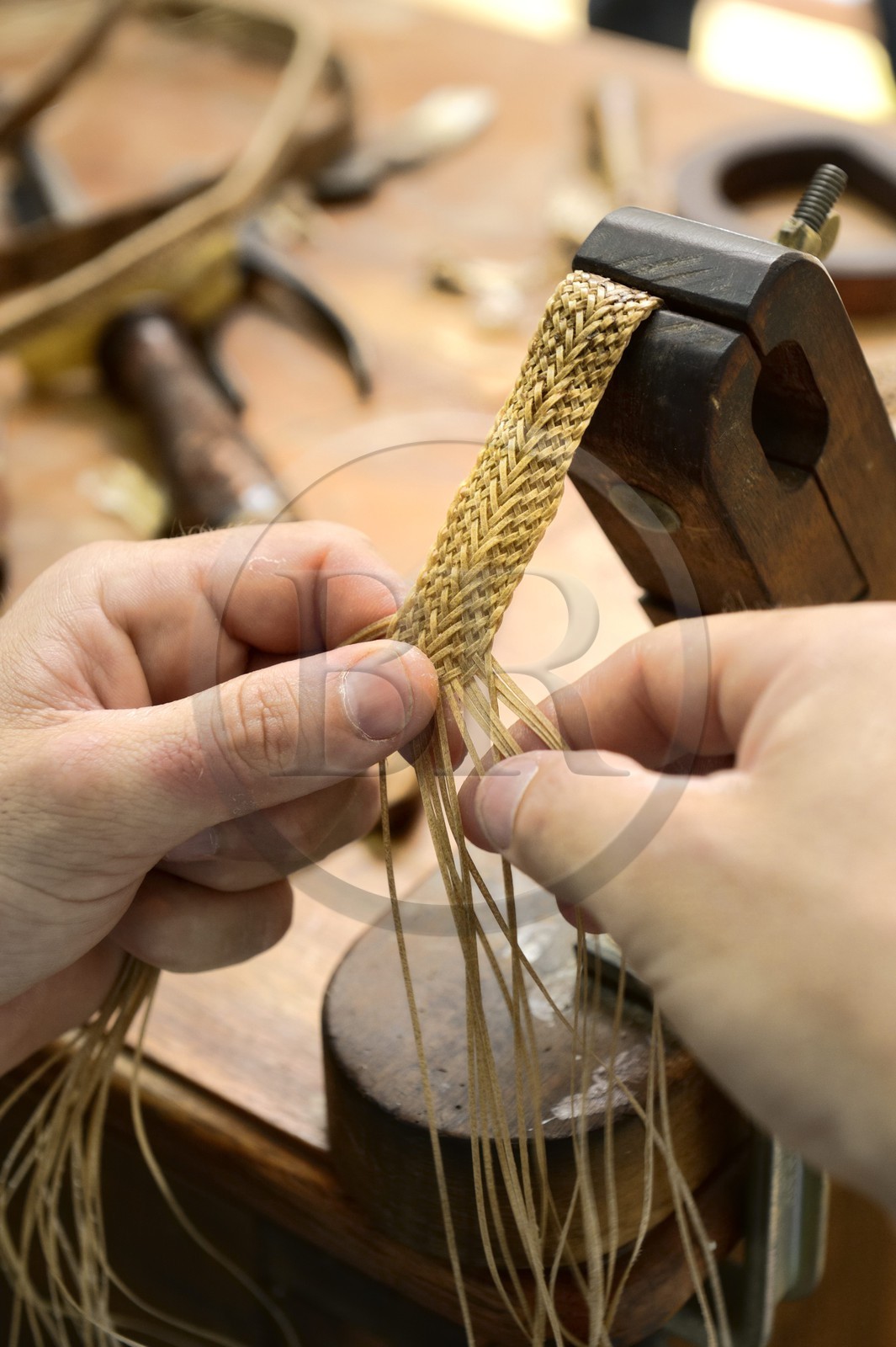 Argentine, province de Buenos Aires, San Antonio de Areco, Alejandro Alvarez tresse le cuir des pièces de l'harnachement des chevaux dans son atelier